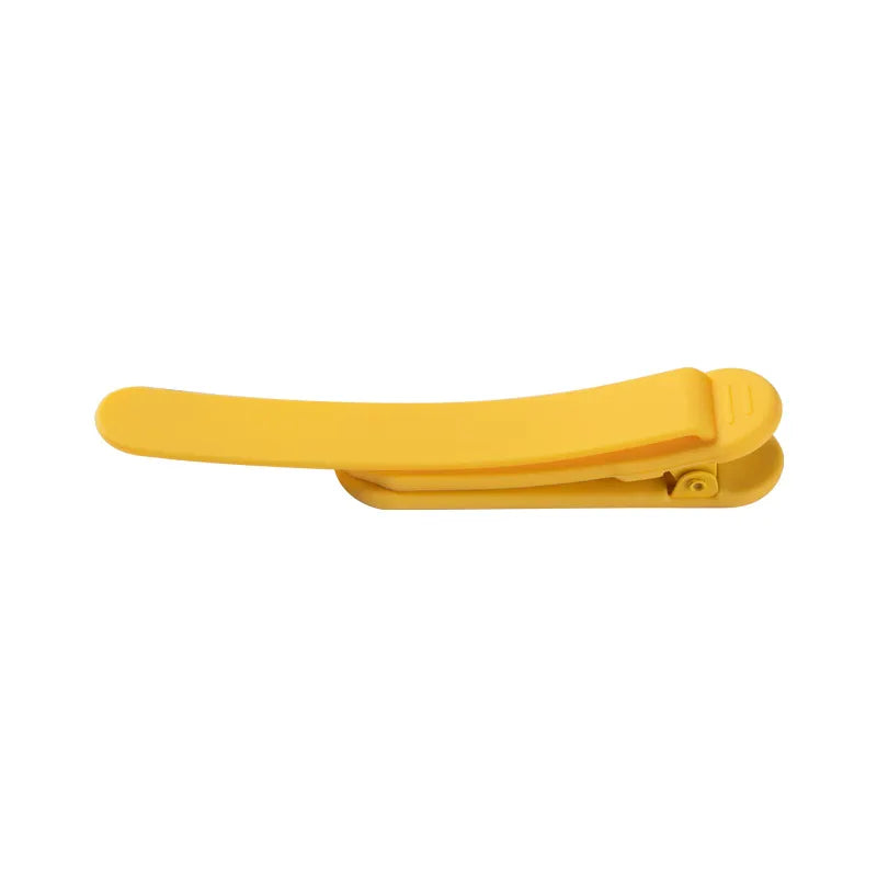 A yellow silicone bookmark holder designed to clip onto a page, displayed on a white background.