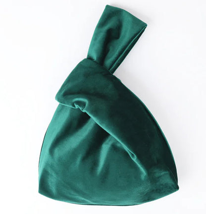 A red silk satin handbag with a knotted handle, displayed against a white background.