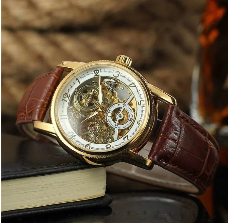 A skeleton mechanical watch with a black faux leather strap and a silver alloy case, featuring a transparent dial showcasing the automatic mechanical movement.