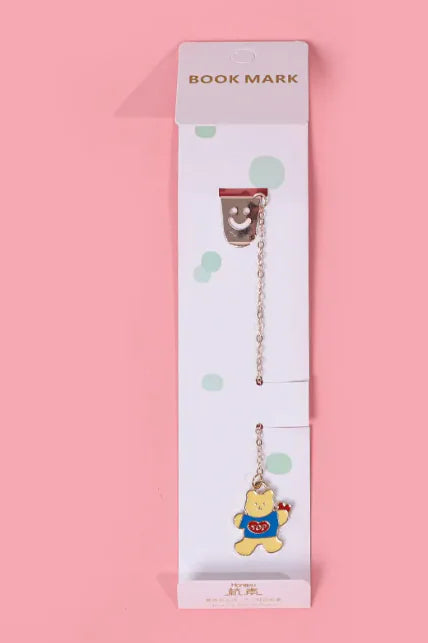 A packaged bookmark with a cute ghost-shaped charm on a pink background.
