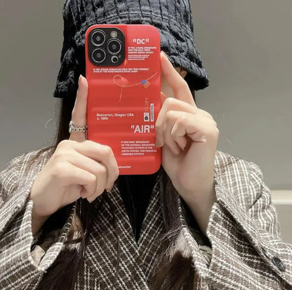 A black iPhone case with text and a graphic design, held in a person's hand.