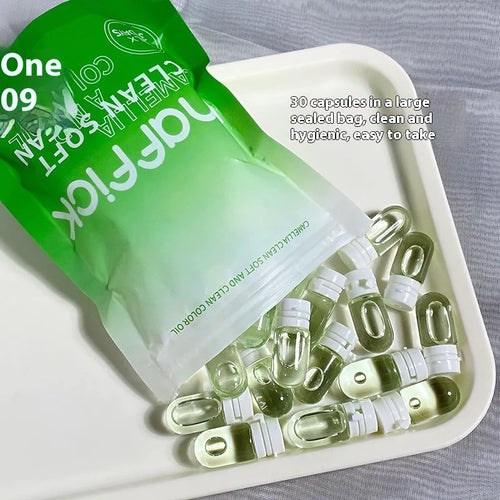 A travel size camellia cleansing oil product with capsules fanned out on a tray, with the packaging indicating it is a hydrating and easy-to-use facial cleanser.