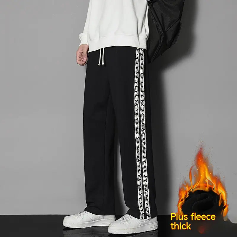A person wearing black straight-leg casual exercise pants with a white drawstring waist and white decorative stripe details on the sides. The image has a 'Plus fleece thick' caption indicating the pants have additional lining for warmth.