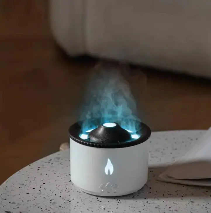 An ultrasonic essential oil humidifier with a volcano-like pattern emitting mist, illuminated by an artificial flame light.