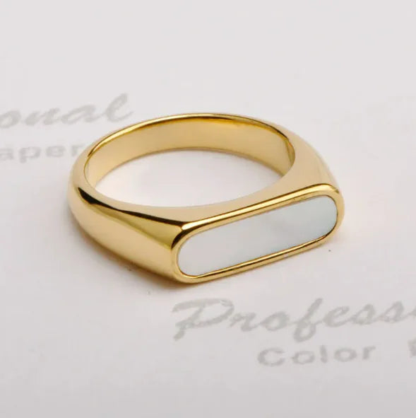 A gold-colored titanium ring with a black and white fritillary design, displayed on a white surface with printed text.