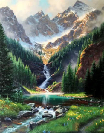 A diamond painting kit depicting a landscape with a waterfall, mountains, and a clear sky being assembled on a table.