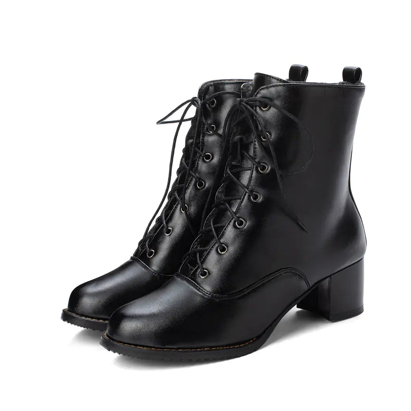 A pair of black mid-calf chunky heel Martin boots with lace-up front and round toe shape.